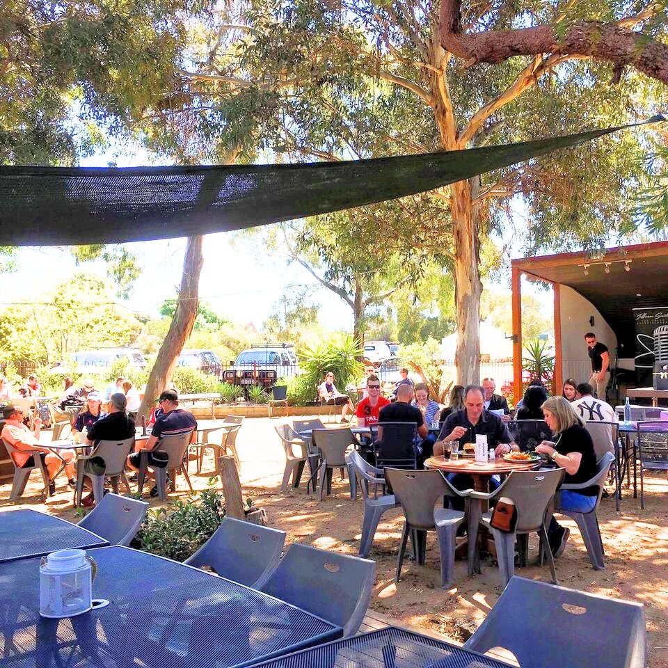 Families and friends eating together under the trees in the Axedale Tavern beer garden